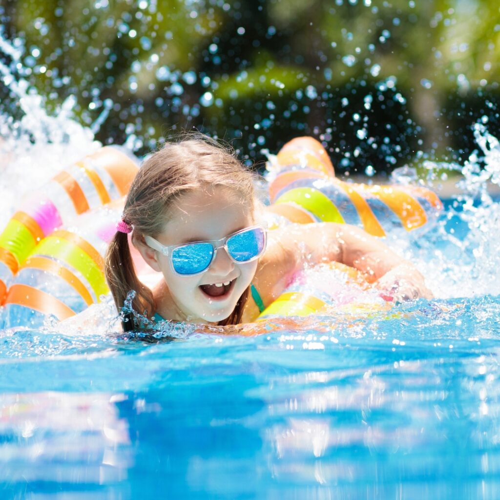 kid playing in pool with floaties