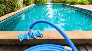 a pool vacuum sitting ready near a clean pool