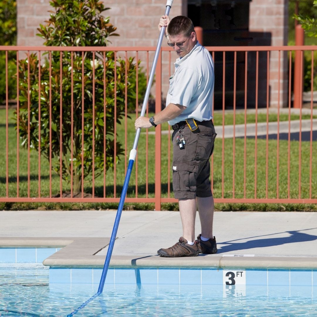 man cleaning pool